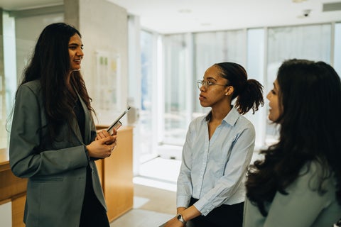 three women standing and talking