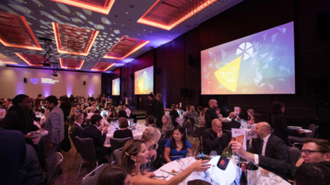 PIEoneer award ceremony with screens and tables of people