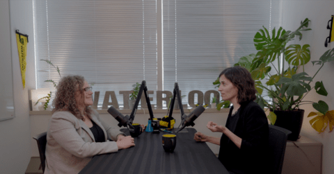  Jodi Szimanski (left) and Jennifer Woodside (right) sitting in a bright room with plants and microphones.