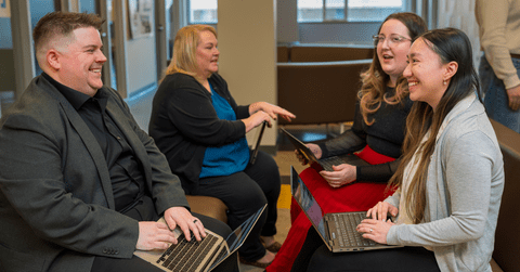 Four people talking and collaborating in an academic setting 