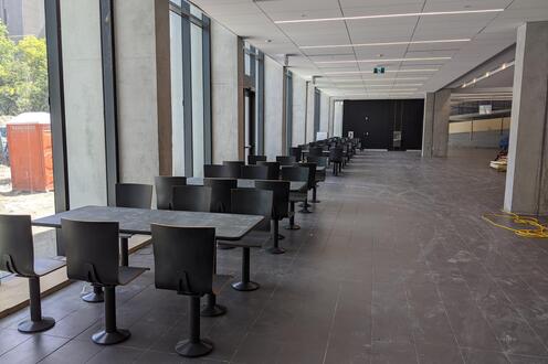 Tables and chairs in a row along windows in the SLC/PAC expansion