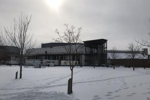 A view of the new SLC/PAC Expansion from the east showing the building under construction and snow and construction vehicles.