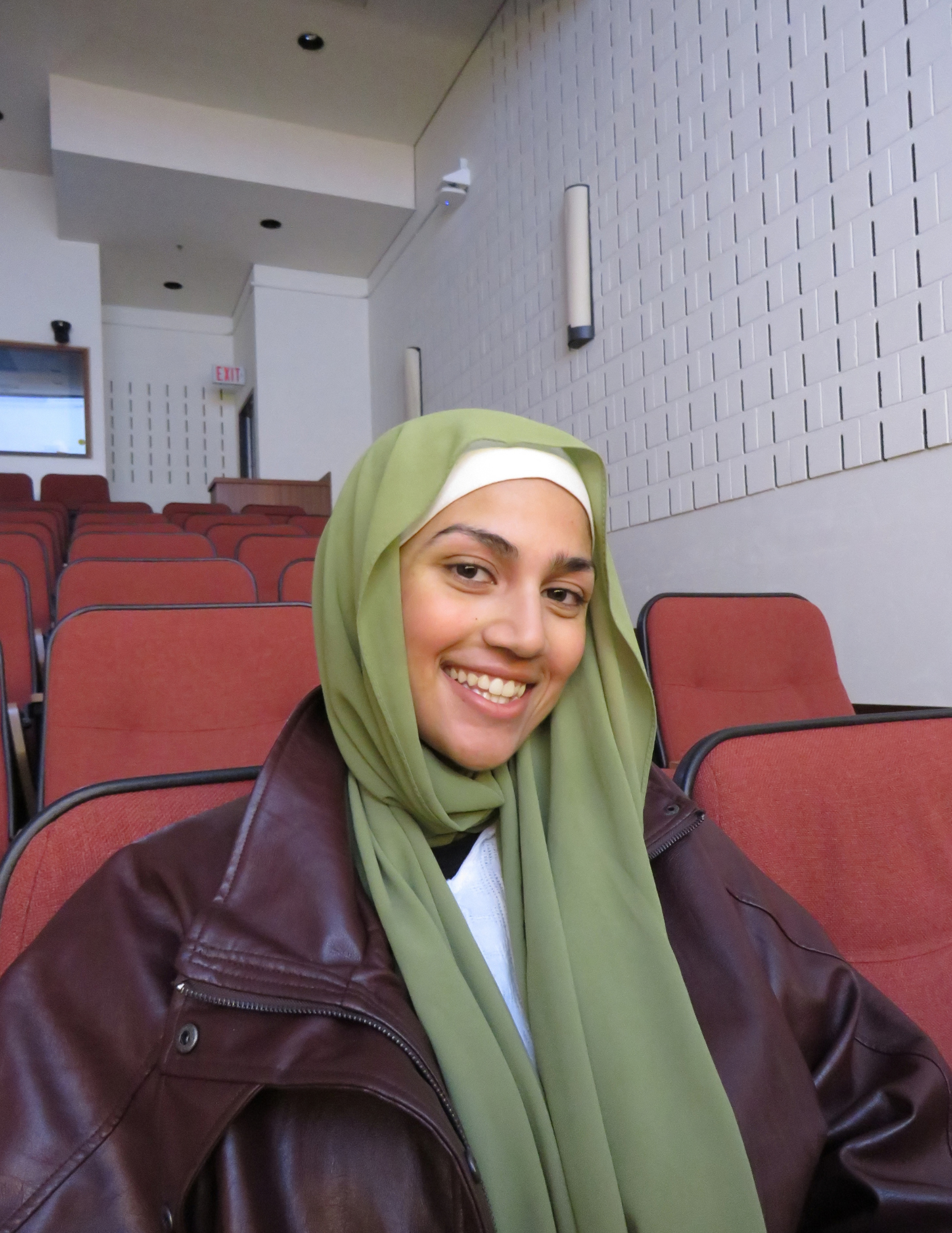 Hafsa sitting on an auditorium chair