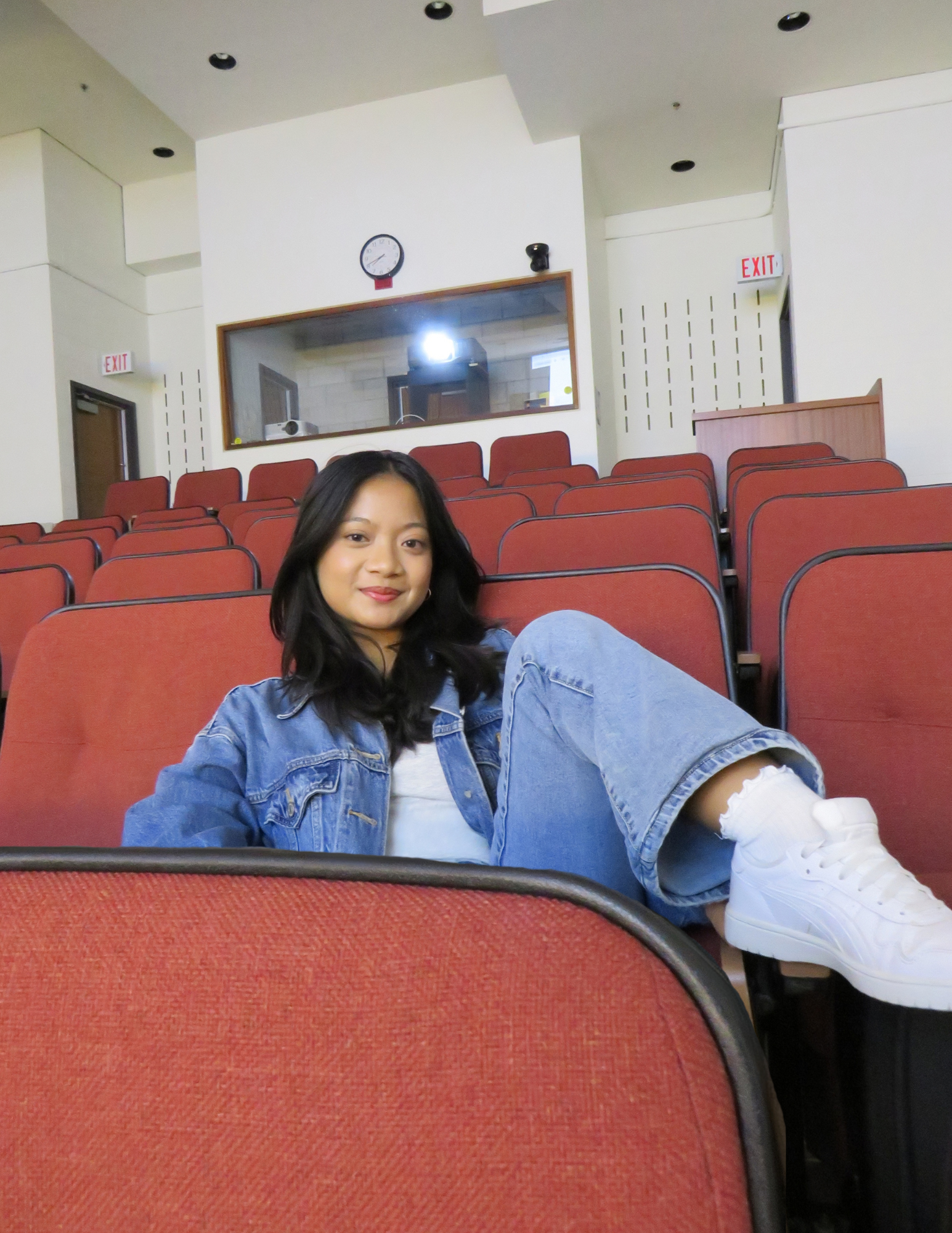 Julia lounging on an auditorium chair