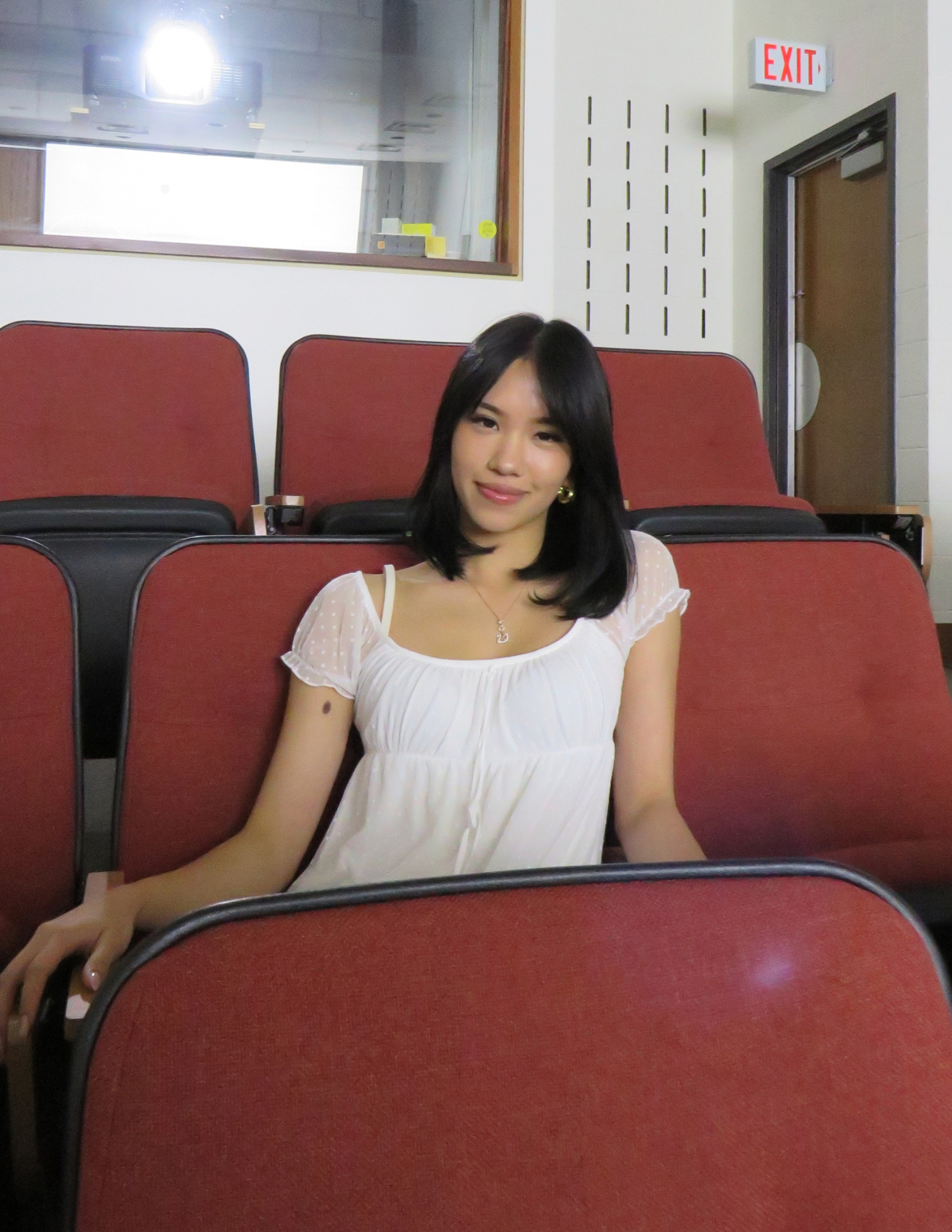 Sam sitting on an auditorium chair