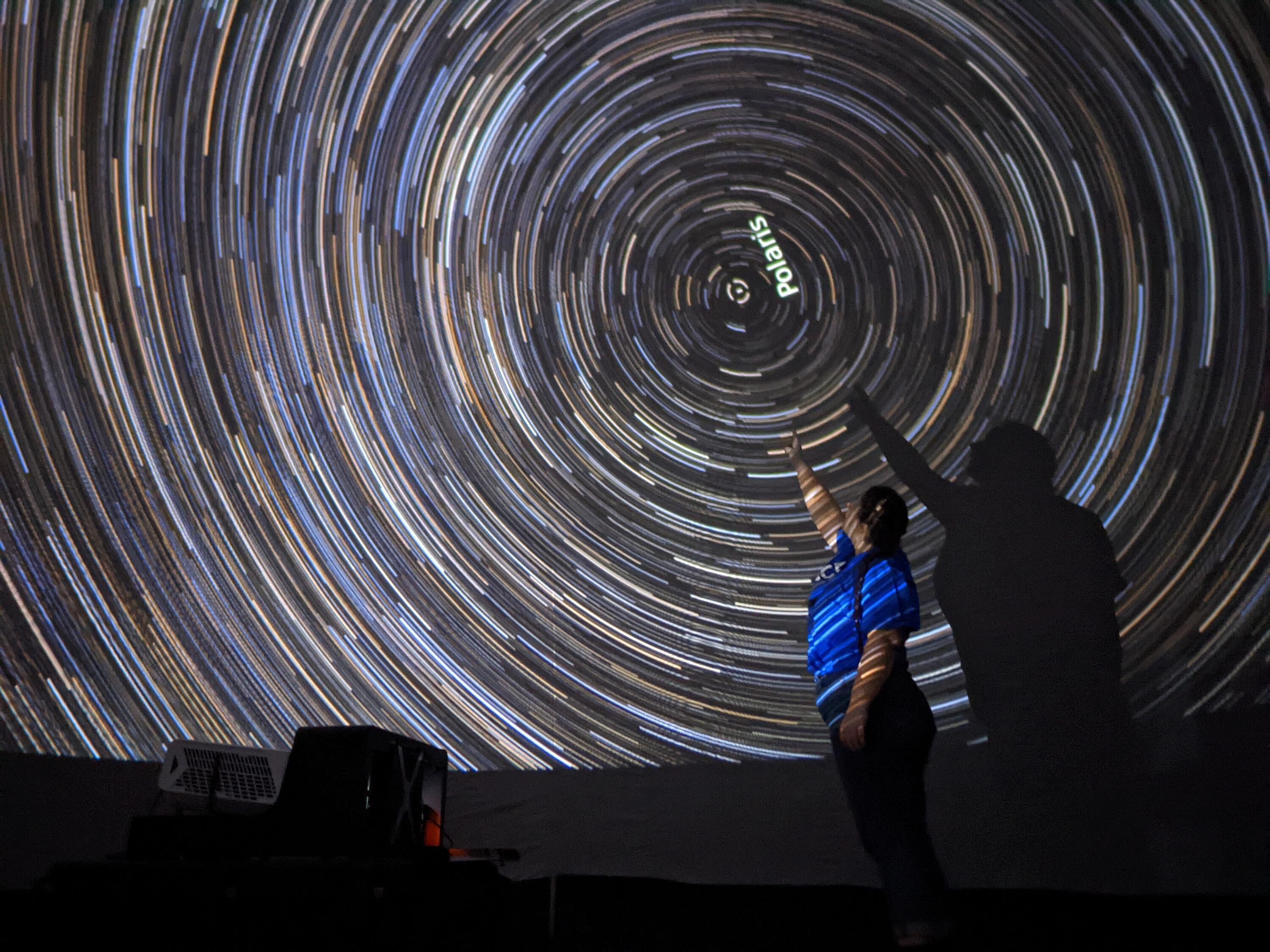 An Astro-Bubble presenter inside the planetarium, pointing at the North Star