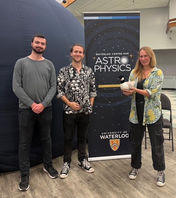 Cam Morgan, Roan Haggar, and Liza Sazonova stand outside the Astro-Bubble planetarium