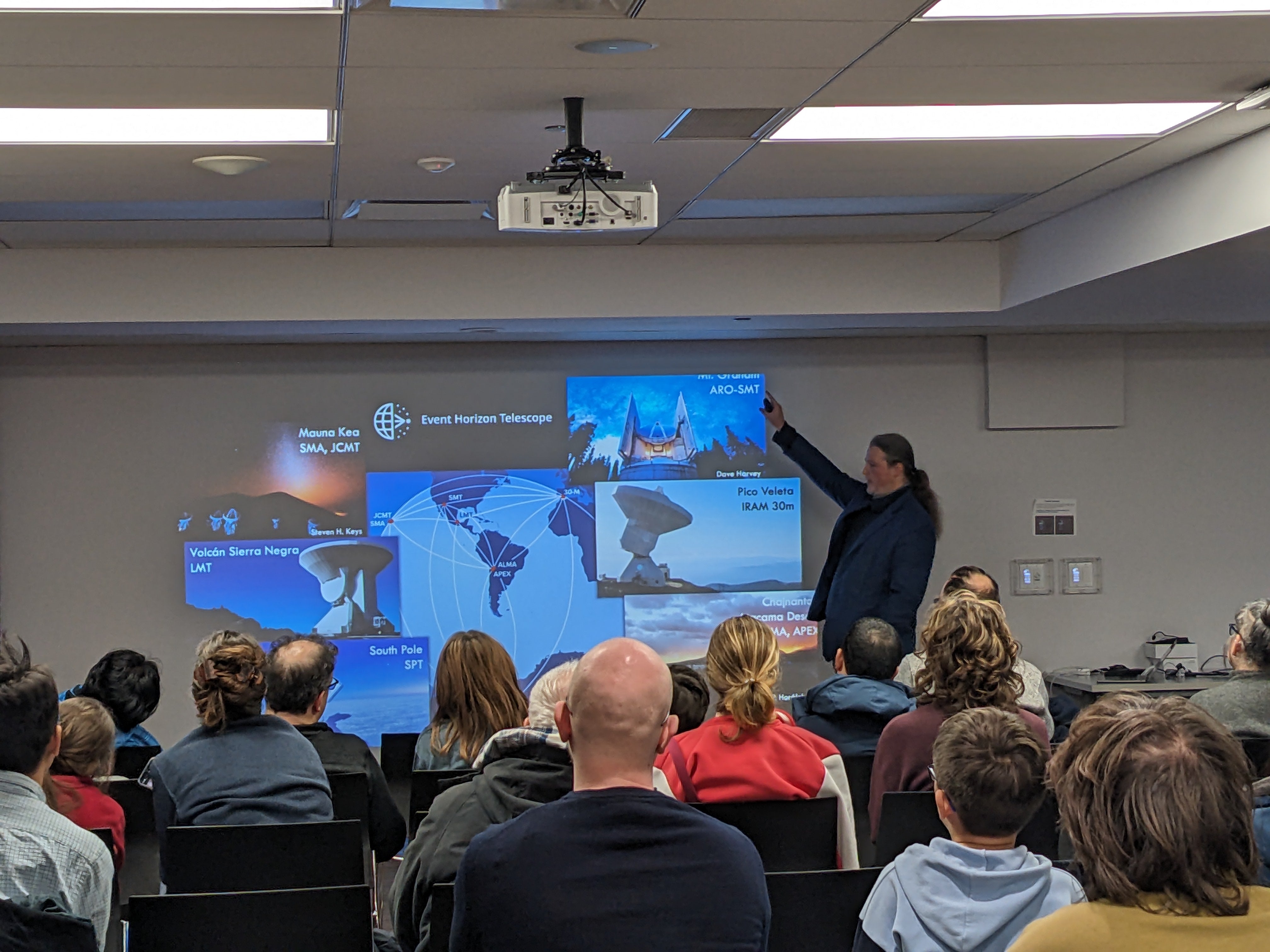 Avery Broderick speaking to an audience about the Event Horizon Telescope