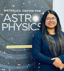 Dr Syeda Lammim Ahad standing by the WCA banner.