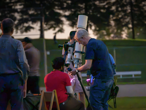 Two stargazers looking through a telescope