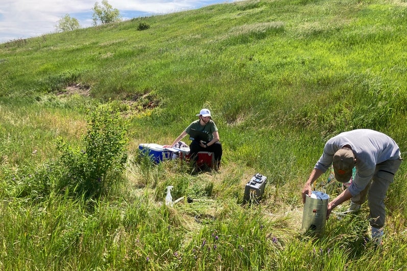 Emma Roy et un autre membre de l’équipe mesurant le flux de méthane sur un site de décharge fermé à l’été 2023.