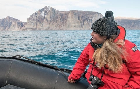 Cassandra sitting in a boat that's travelling to glaciers in the Canadian Arctic