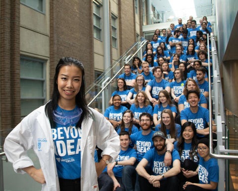 link, Tens of Science student wearing tshirts that say Beyond Ideas posing in a stairwell.