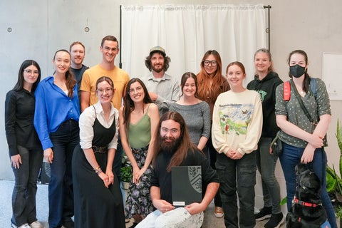 A group of students in front of a white curtain. 