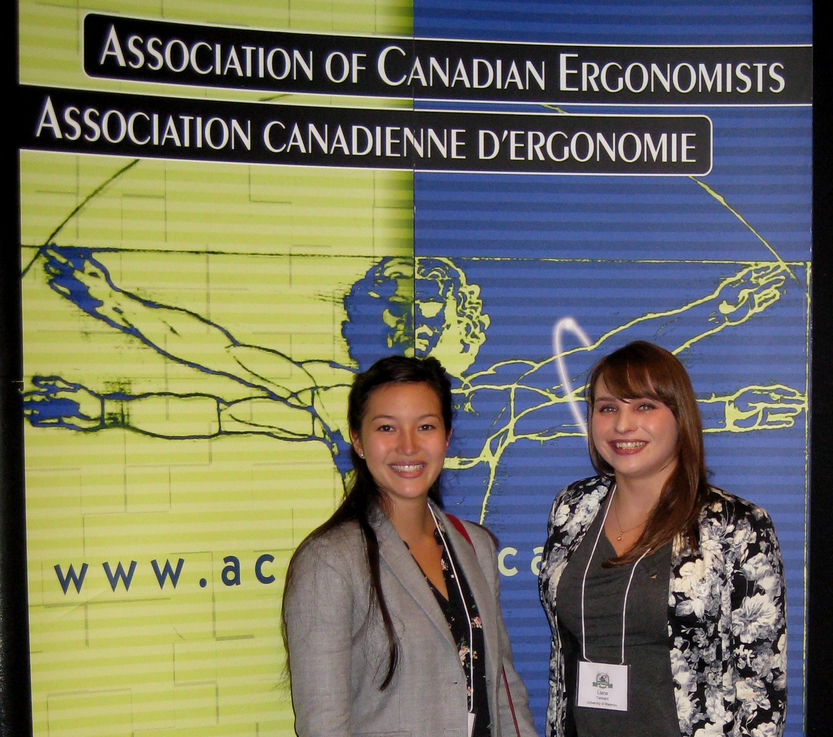 Helen and Liana infront of the conference banner