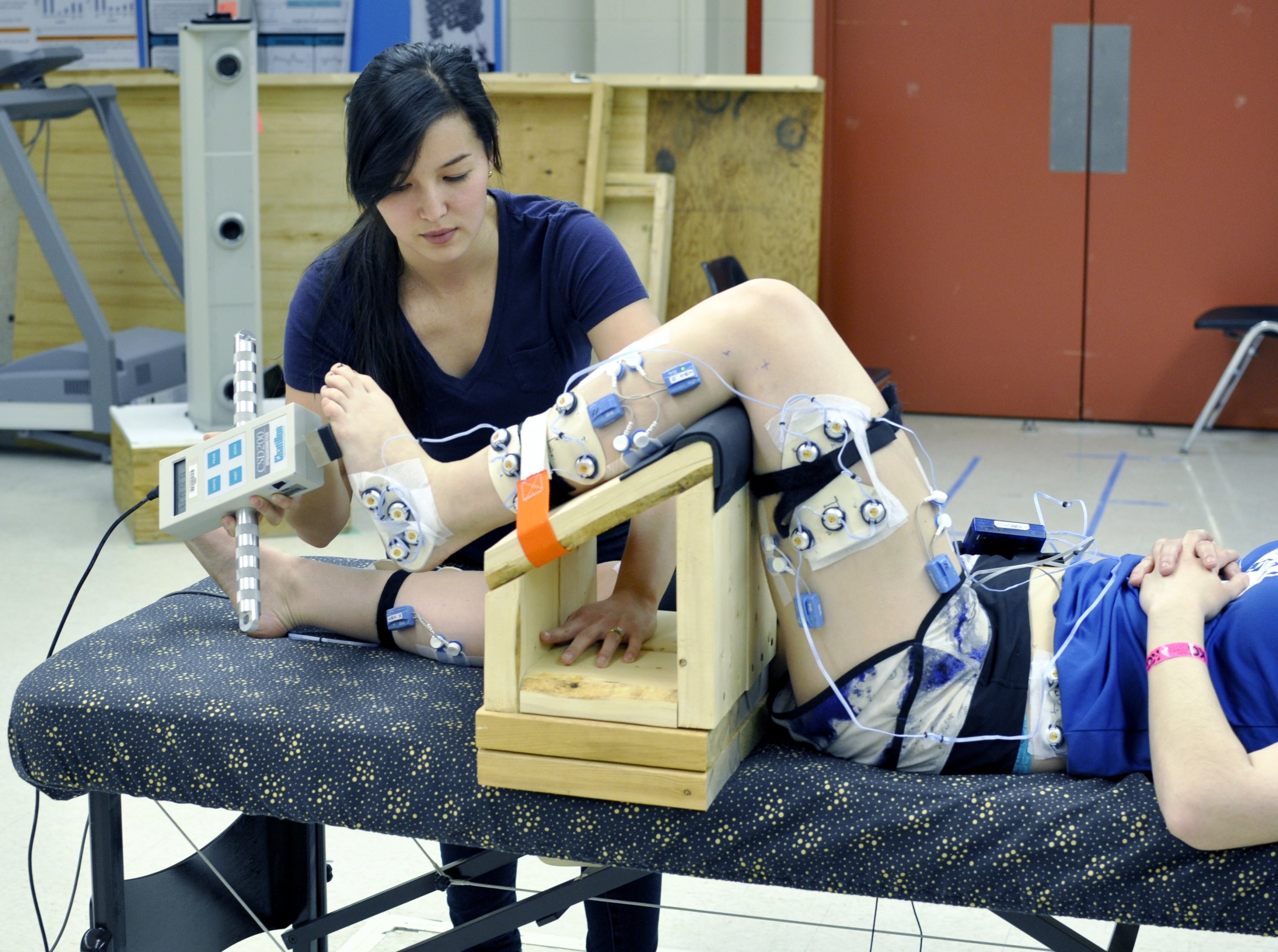 Participant's leg supported by a 90 degree jig and researcher pushing foot up 