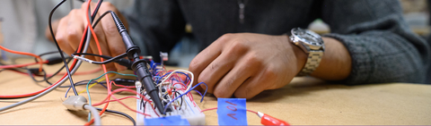 Student working on mechanical part with their hands 