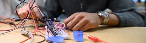 Student working on mechanical part with their hands 