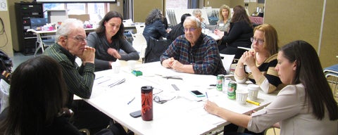 Professor, students and older adults consulting at workshop.