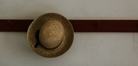 A straw hat hooked on a wall