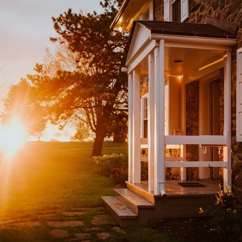 Bright sunset, with a view of the small front porch of Brubacher House