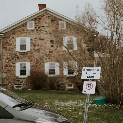 View of Brubacher House with a staff parking sign, fall.