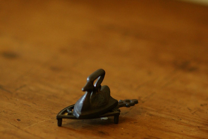 A black metal item, small, with a ring hook on top. Bell shaped