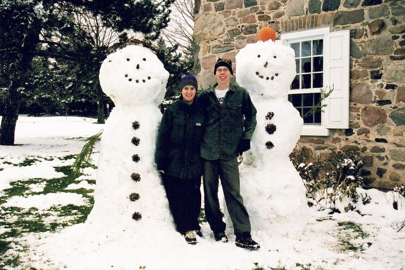 colin and Jennie stand beside snowmen