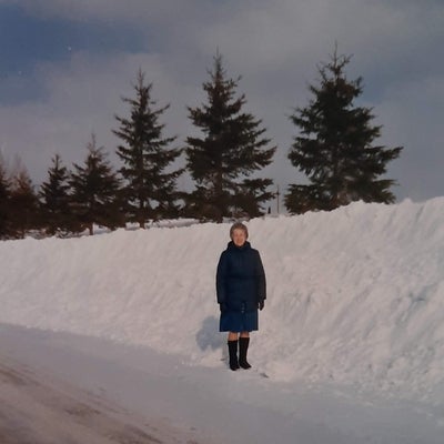 Dorothy stands beside a large snowdrift