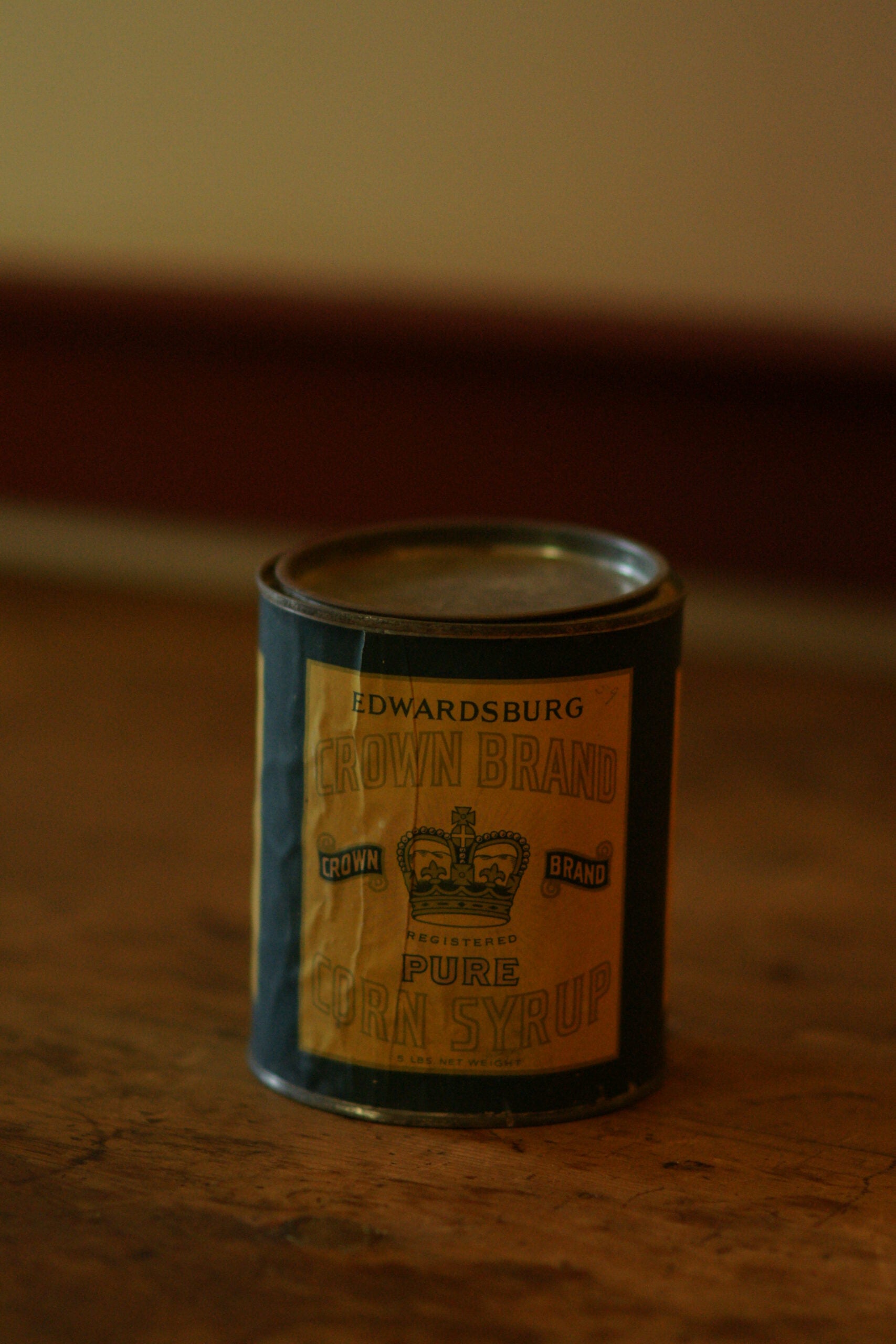 A can with clear signs of age, labled "edwardsburg Crown Brand Corn Syrup" on a yellow and blue label