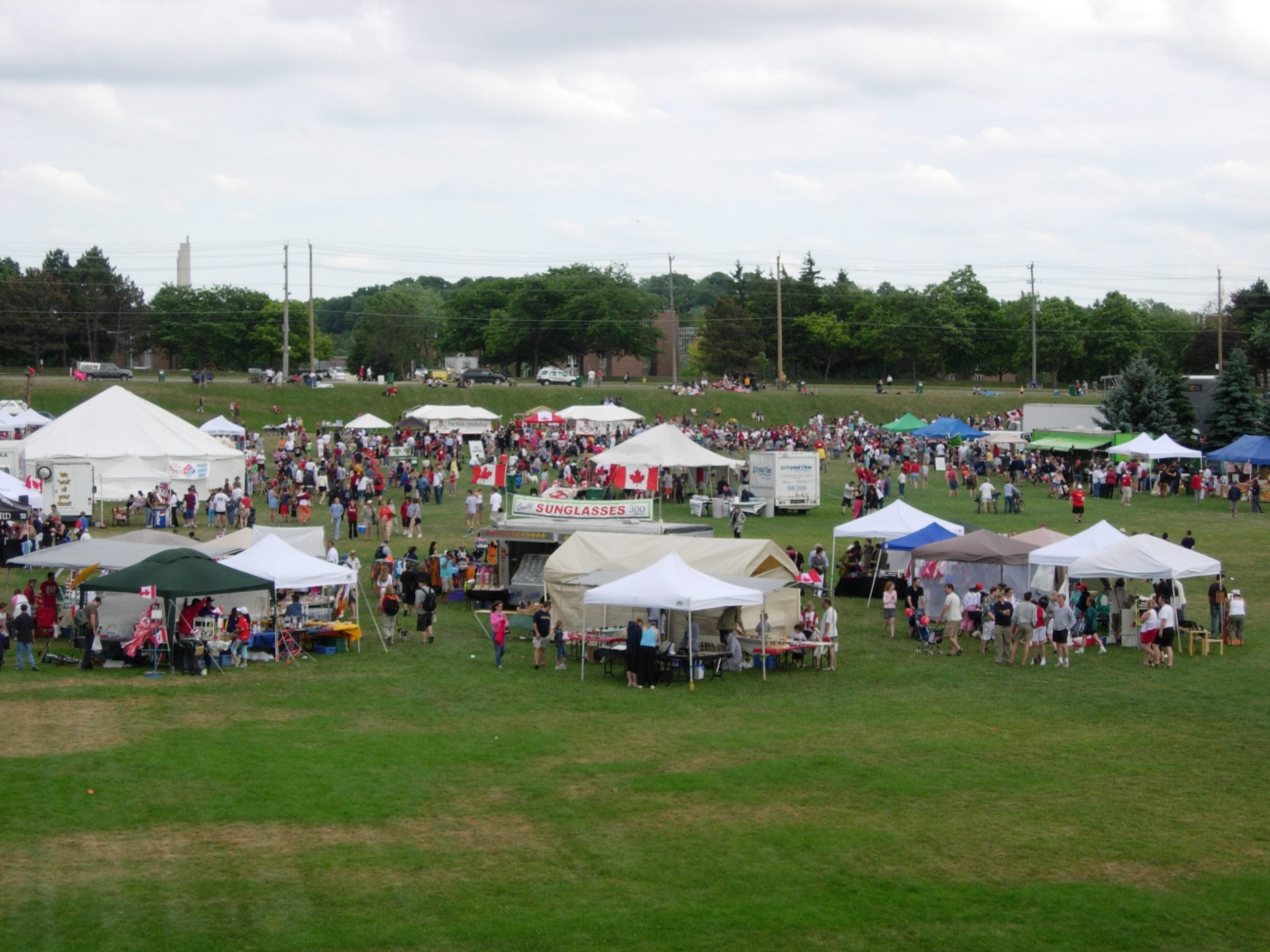 A view of Colombia Lake fields, with white tents set up for a crowd of people enjoying Canada Day