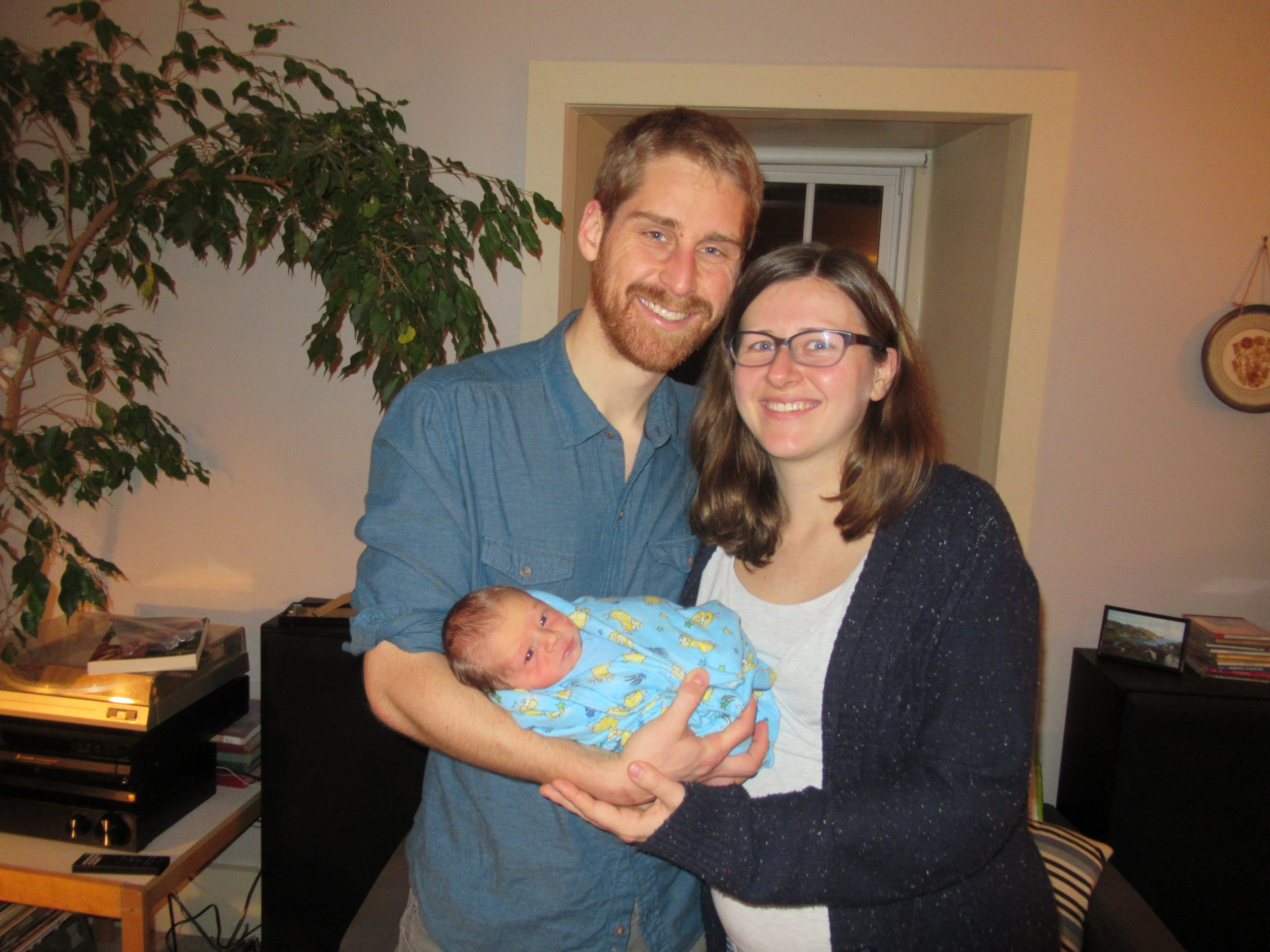 Laura and Josh hold new born baby Oren in Brubacher House