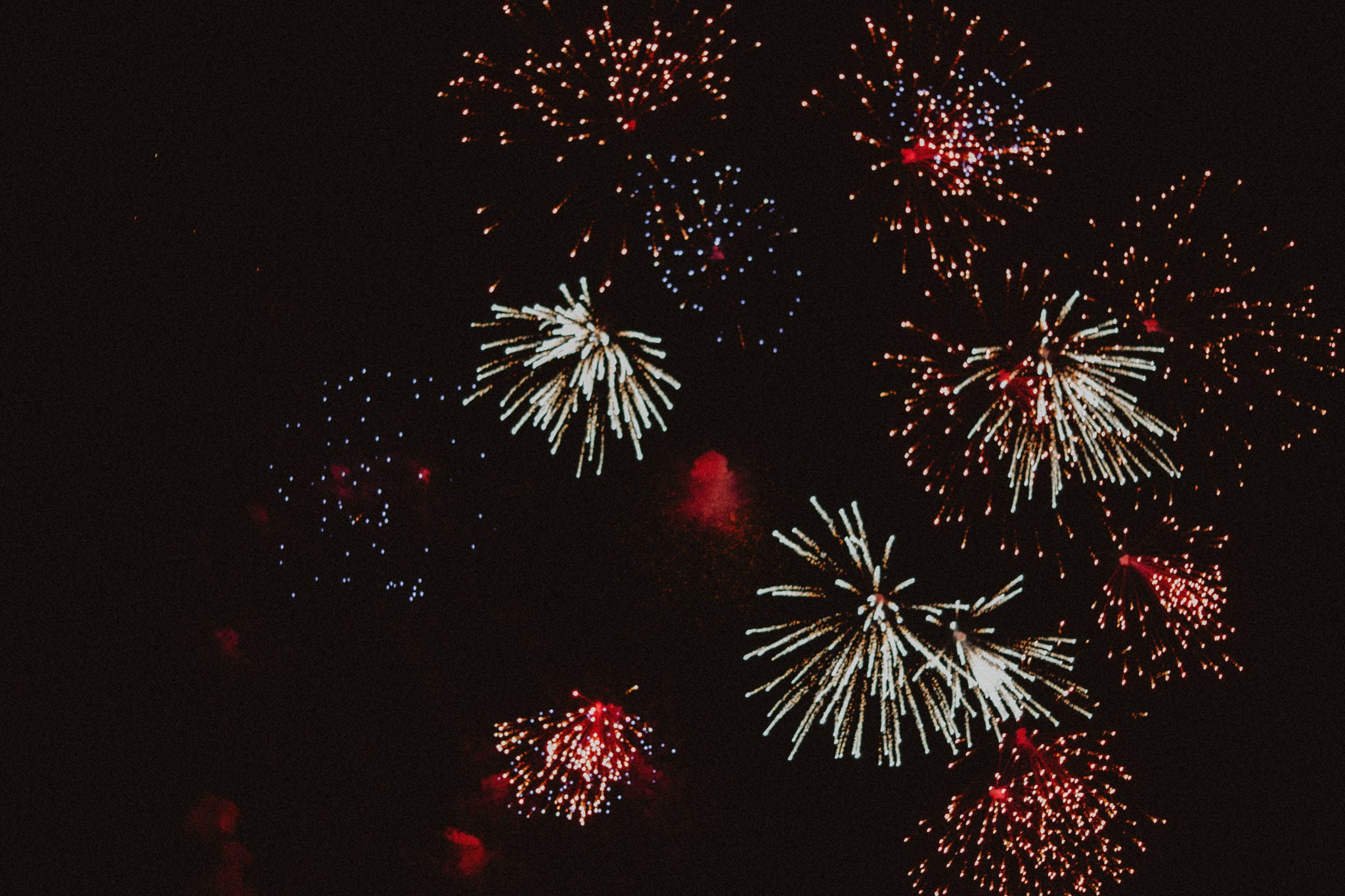 A sky full of various fireworks, sparkling in red and white