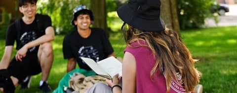 3 student outside under a tree