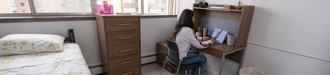 Student studying in suite style bedroom