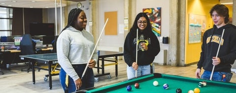 3 students playing pool