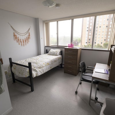 UWP single room with a twin bed against the left wall and a desk and chair on the right wall.