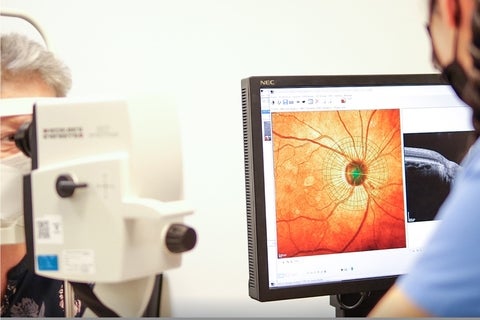 A researcher looks at a live image of an eye on a computer screen.