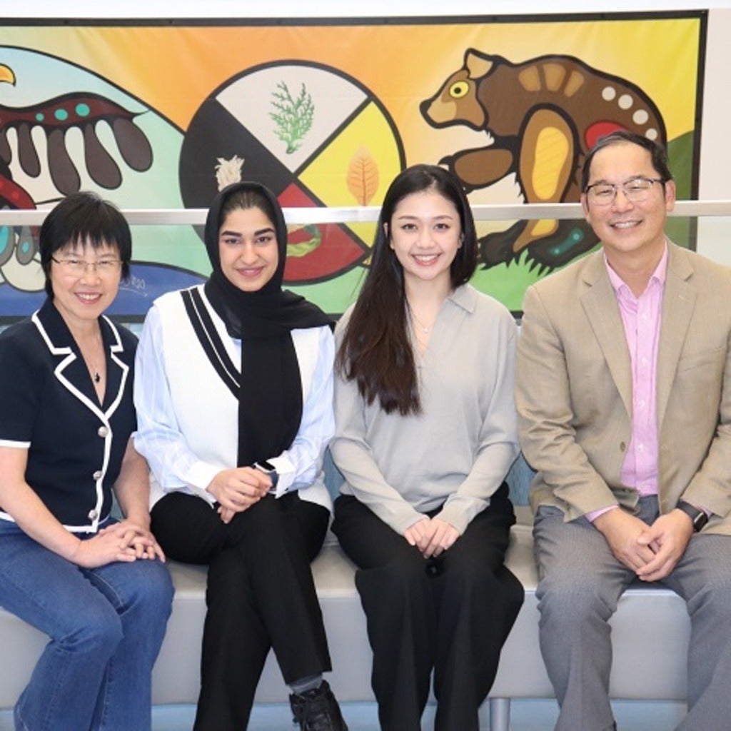 the Can-View team sits in front of an indigenous painting