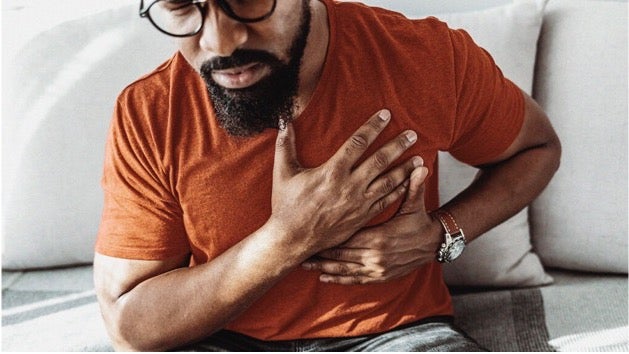Male patient holding hand to his chest.