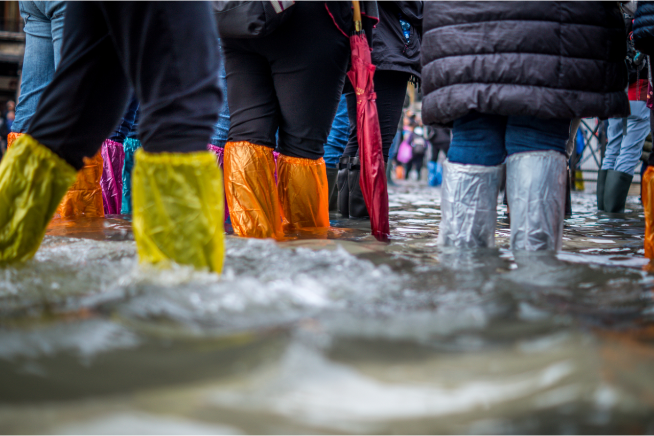People standing in deep water with colourful rainboots