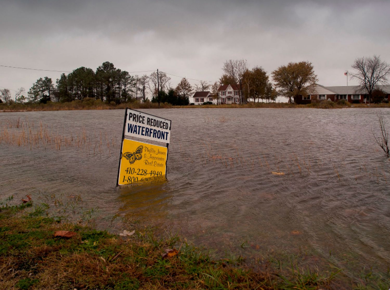 Flooded property with a sign half in the water