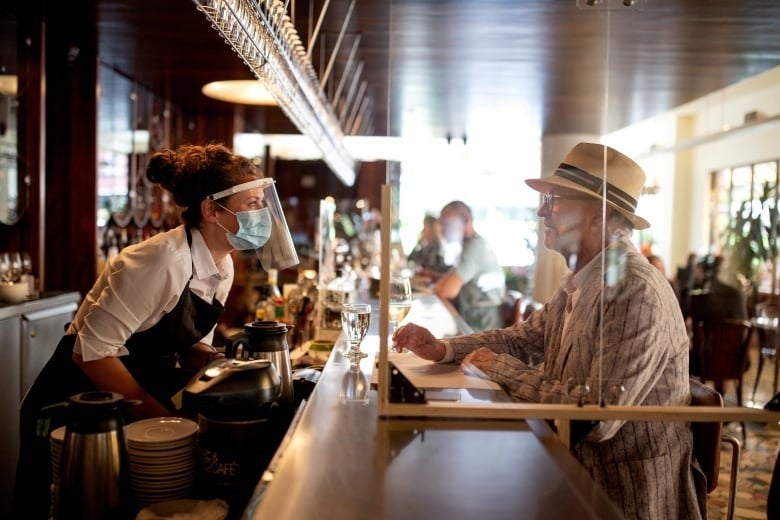 Back in the good old days in Montreal before the Thanksgiving lockdown, a bartender talks to a patron on June 22, the first day after COVID-19 restrictions were lifted on restaurants.