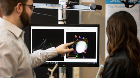 Man and woman looking at screen with 3D graphic on display