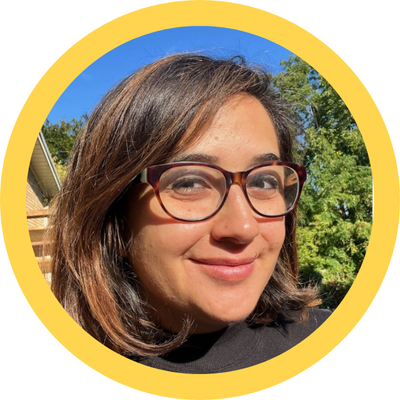 woman wearing glasses outside in front of trees