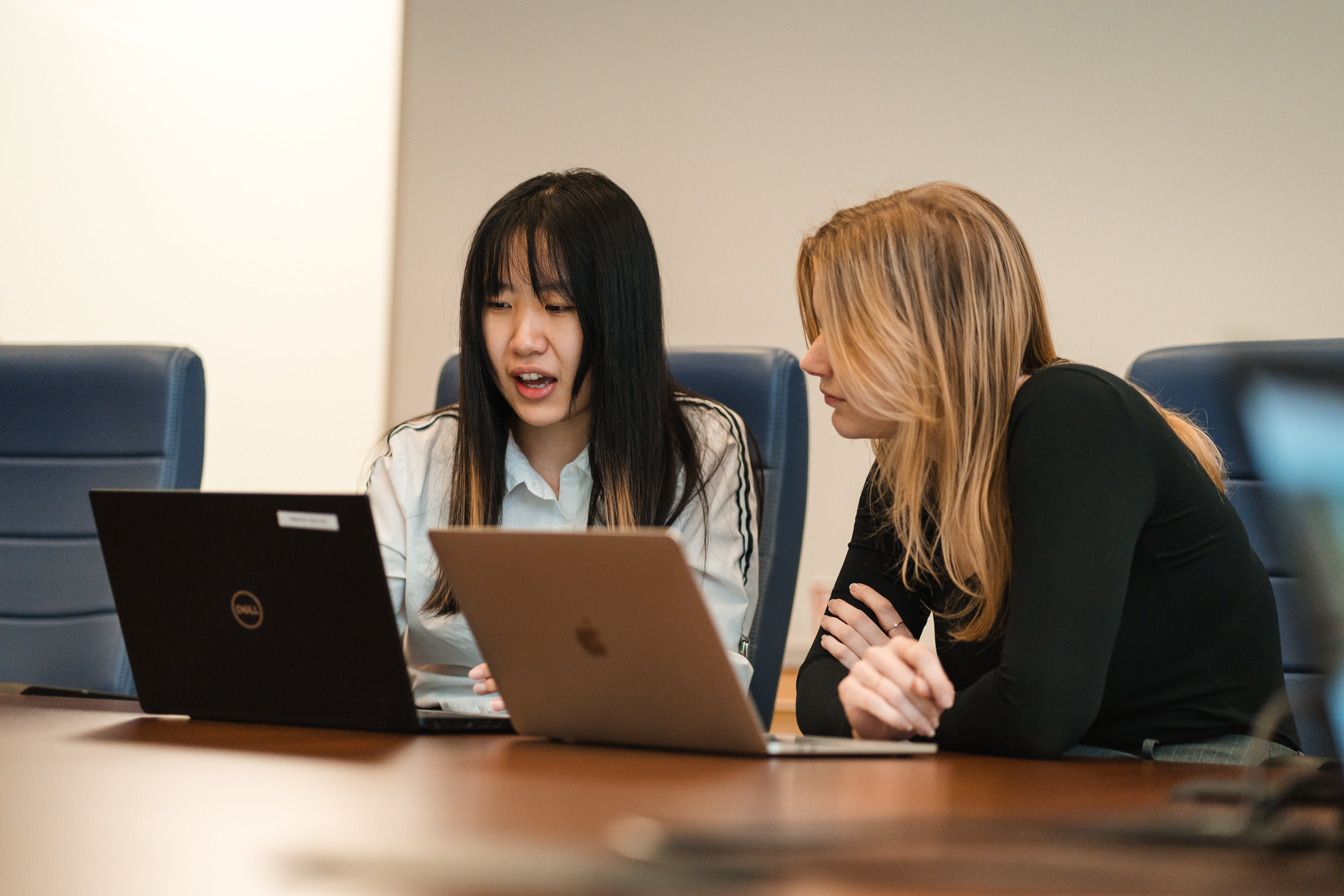 two females looking at laptops