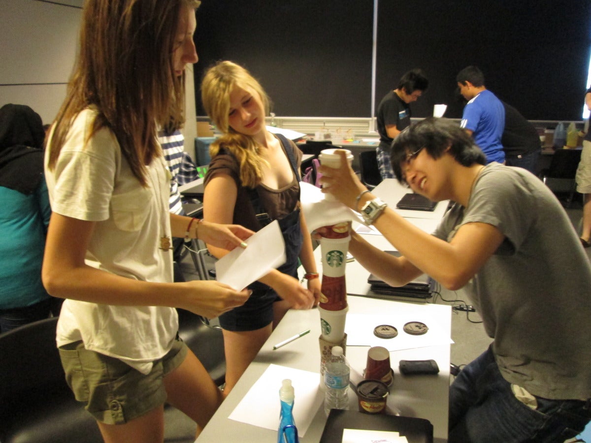 Summer Leadership participants using coffee cups to design a structure