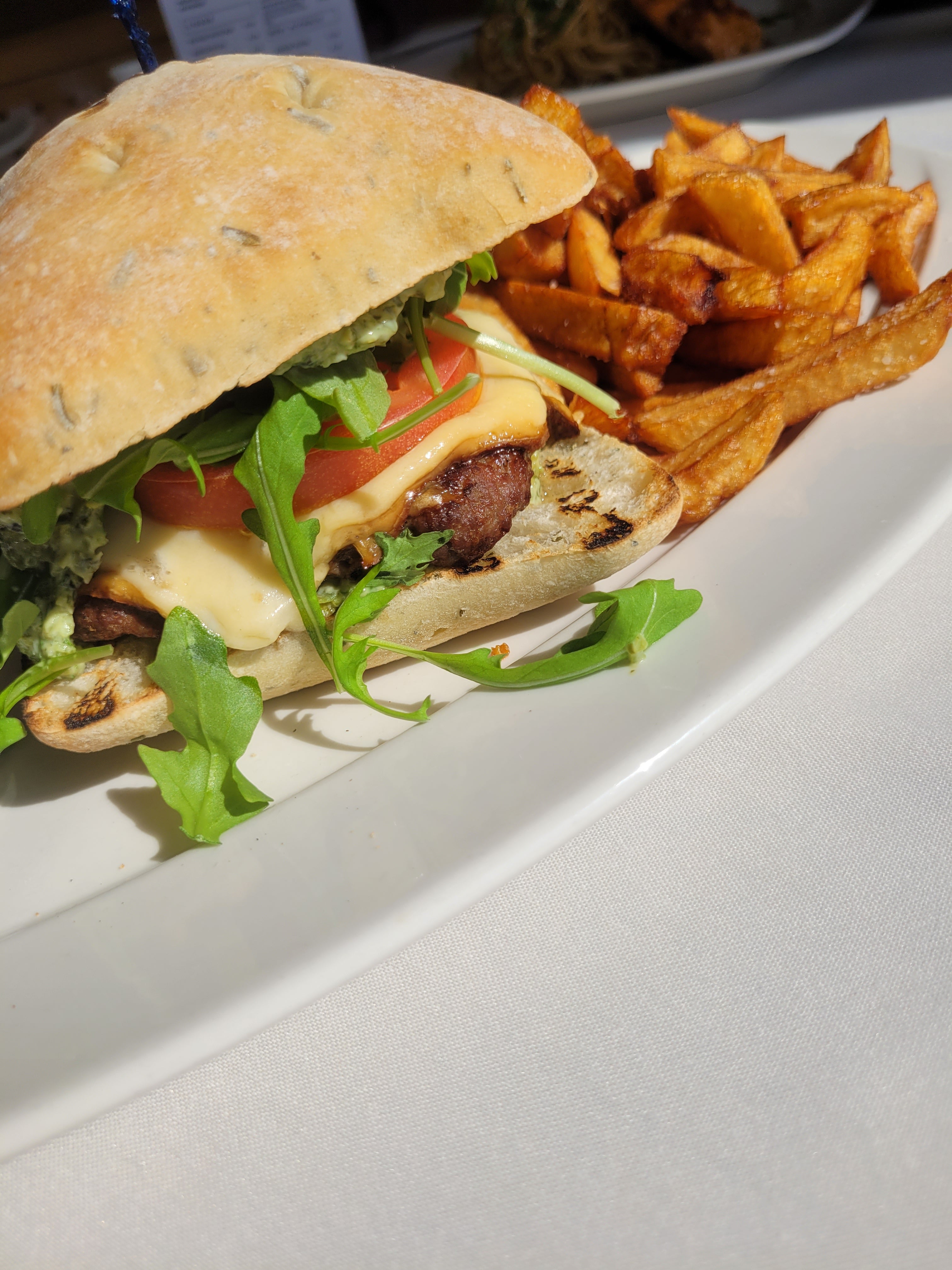 Grilled lamb burger with mint chutney, smoked gouda cheese, lettuce, tomato and a side of fries 