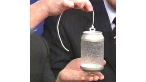 Man holding aluminum can with plastic liner exposed on string.