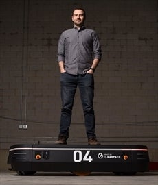 Matt Rendall, CEO and co-founder of Clearpath Robotics, stands on an OTTO 1500, the self-driving heavy load materials transporte